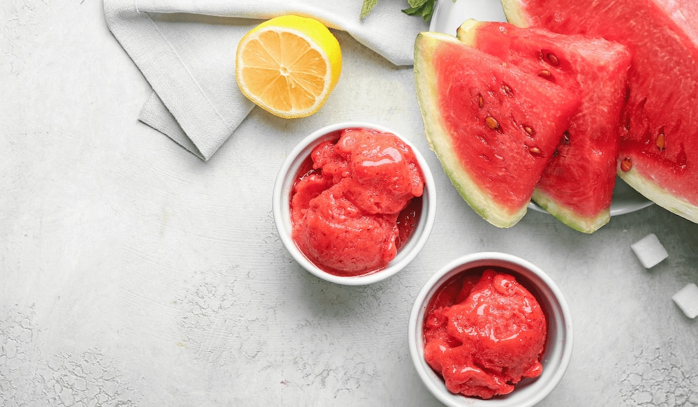 Wassermelonen Sorbet in einer Schale mit Wassermelonen Stücken daneben