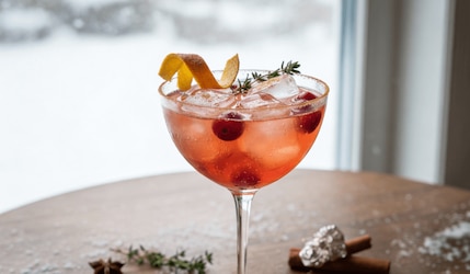 Winter Spritz Cocktail auf einem Holztisch angerichtet