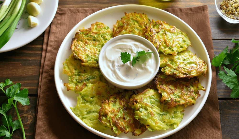 Zucchini-Puffer auf einem Teller angerichtet