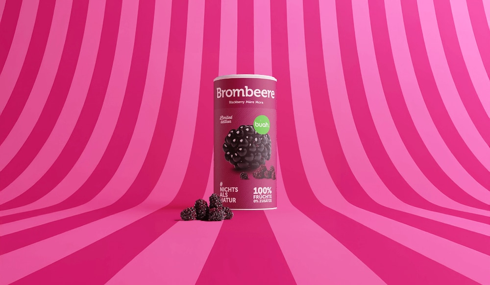 Packung buah Brombeere vor pinkem Hintergrund