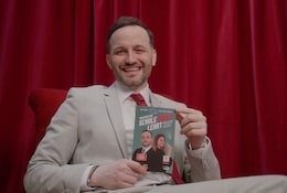 roter Hintergrund, Mann im Anzug hält ein Buch