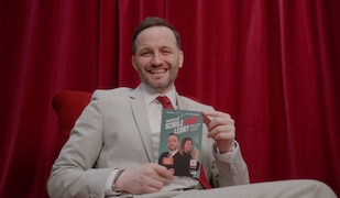 roter Hintergrund, Mann im Anzug hält ein Buch