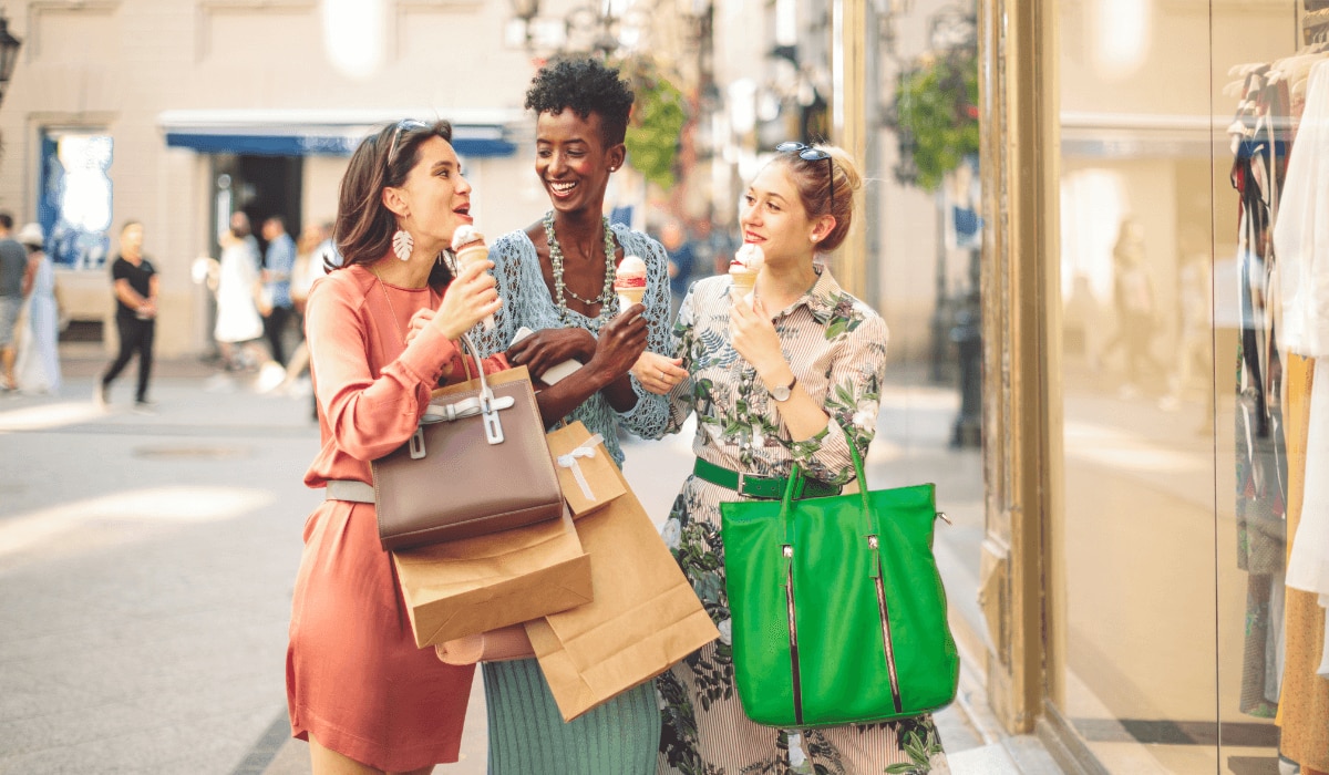 drei Frauen gehen glücklich im Sommer shoppen