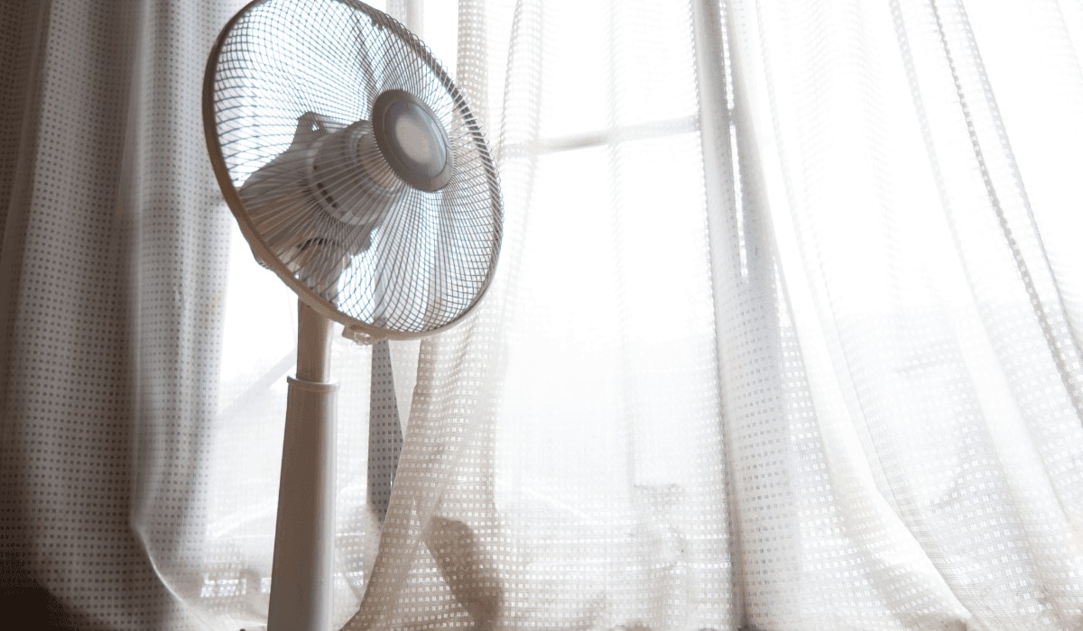 eingeschalteter Ventilator in einem Raum mit Vorhängen