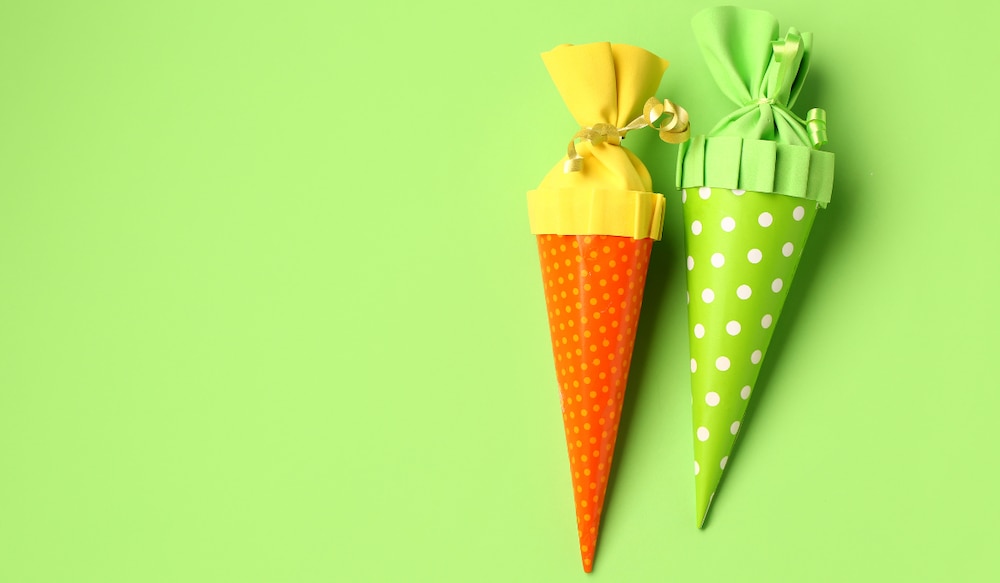 grüner Hintergrund, eine orange und grüne Schultüte.png