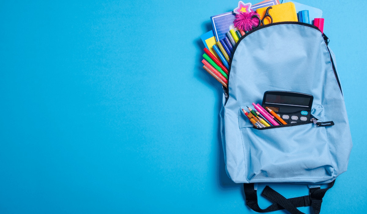 Schulsachen mit Stiften in einem blauen Rucksack