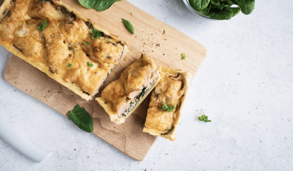 Lachs im Blätterteig mit Spinat auf Holzbrett