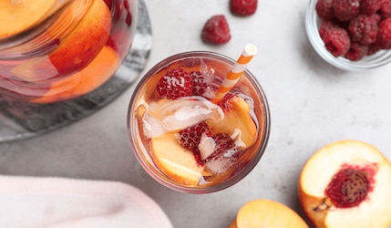 Pfirsich-Beeren-Limo im Glas mit Strohhalm