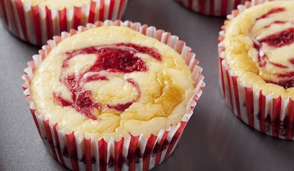 Käsekuchenmuffins mit Himbeeren auf dem Blech