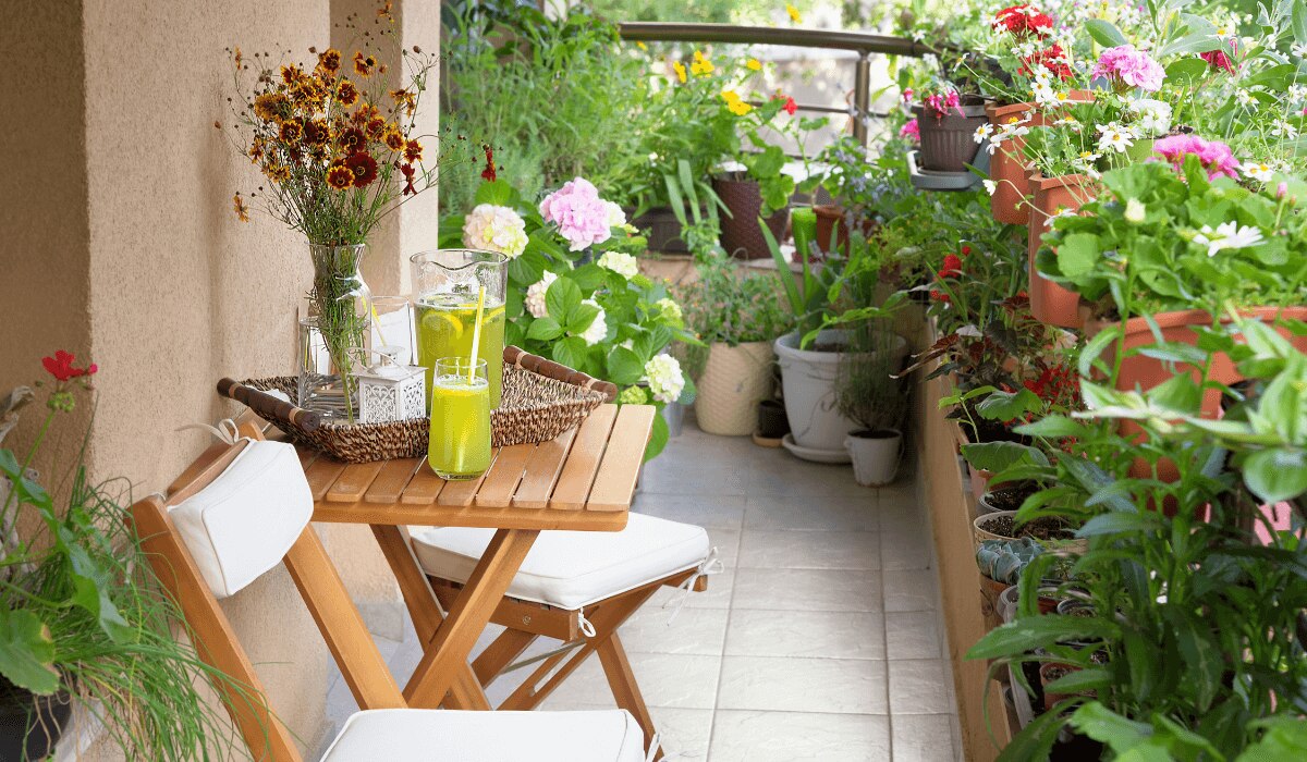 Bepflanzter Balkon mit Stühlen und Tisch