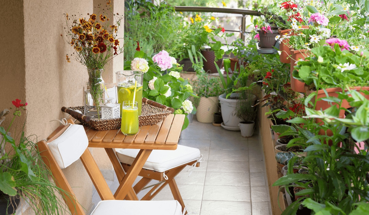 Bepflanzter Balkon mit Stühlen und Tisch