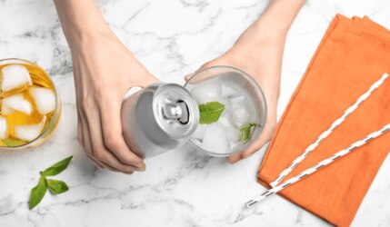 Softgetränk aus der Dose wird in Glas gegossen