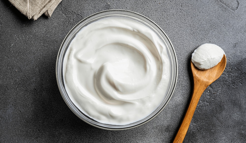original griechischer Joghurt in einer Schale mit Holzlöffel