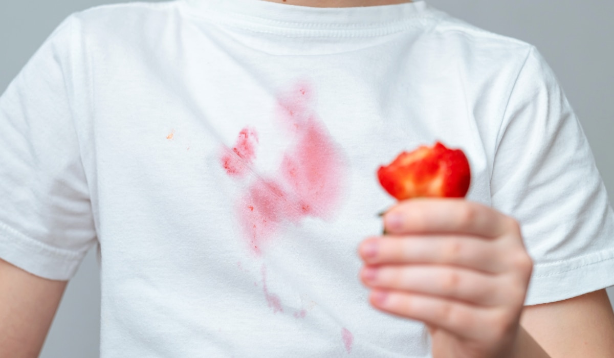 roter Erdbeerfleck auf weißem T-Shirt.png