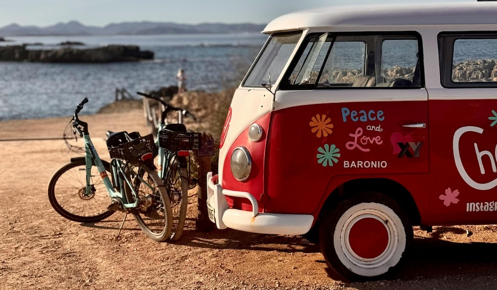 roter VW Bulli Bus an einem Strand